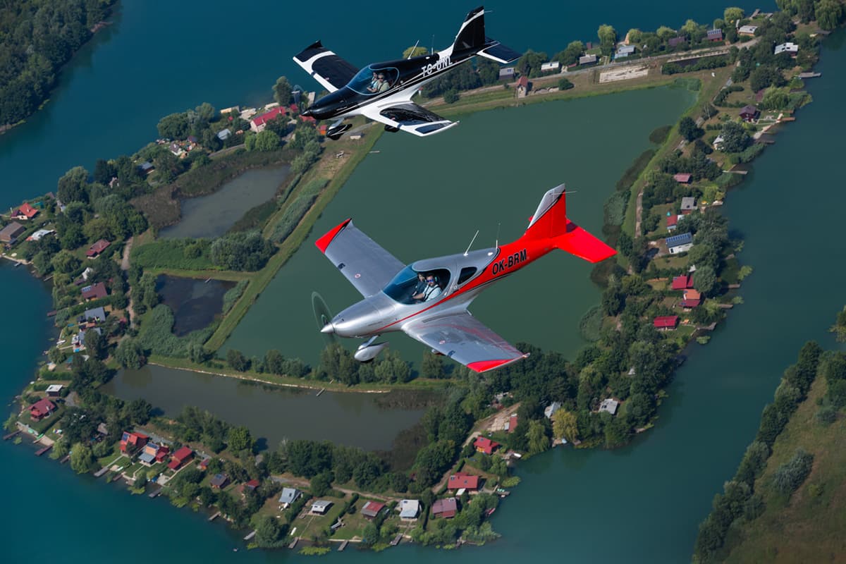 Two Bristell B23 Mosaics in formation over a lake