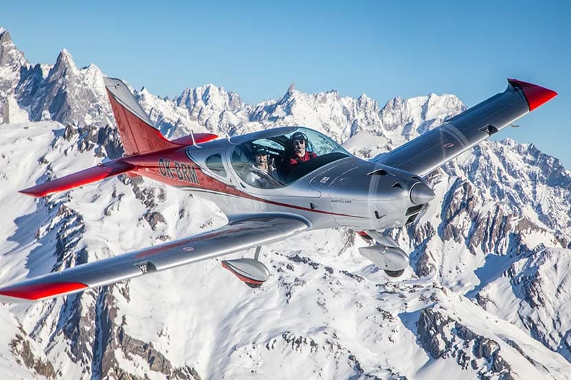 Bristell B23 Turbo climbing past snow-capped alpine peaks